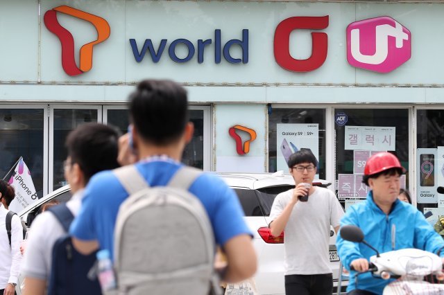 서울 시내의 한 이동통신 판매점 앞을 시민들이 지나고 있다. /뉴스1 © News1