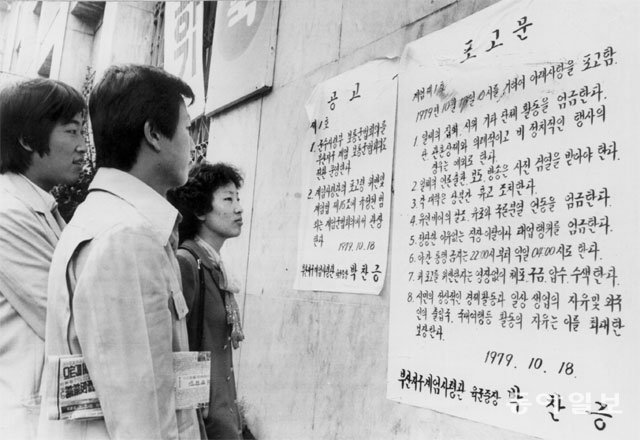 1979년 부마항쟁 당시 부산시청 앞에 게시된 계엄포고문을 지나가던 시민들이 읽고 있다. 동아일보DB