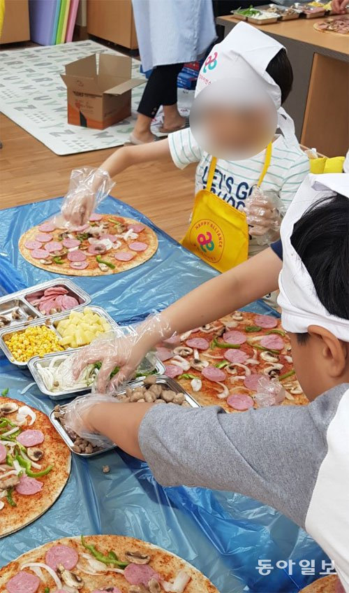 도미노피자의 찾아가는 피자교실 ‘도미노 파티카’ 행사에서 아이들이 준비된 식재료를 이용해 직접 피자를 만들고 있다. 대구=조유라 기자 jyr0101@donga.com
