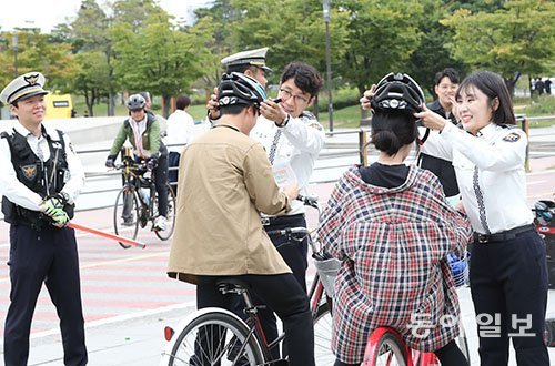 28일부터 새 도로교통법에 자전거 헬멧 의무화가 적용됐다. 서울 한강시민공원 여의지구에서 경찰들이 헬멧을 착용하지 않은 자전거 운전자에게 헬멧 착용 의무화 홍보를를 하고, 헬멧을 씌워줬다. 사진=김재명 기자 base@donga.com