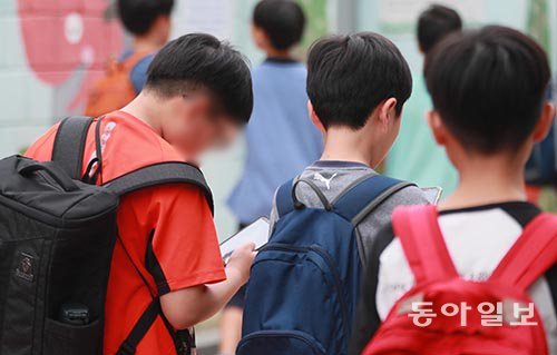 14일 서울 마포구의 한 초등학교 앞 어린이보호구역(스쿨존)에서 하교 중인 초등학생이 스마트폰 화면을 쳐다보며 걷고 있다. 이 
곳은 차량 통행이 많아 어린 학생들의 각별한 주의가 필요하다. 박영대 기자 sannae@donga.com