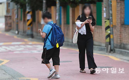 14일 서울 마포구의 한 초등학교 앞 어린이보호구역(스쿨존)에서 하교 중인 초등학생이 스마트폰 화면을 쳐다보며 걷고 있다. 이 
곳은 차량 통행이 많아 어린 학생들의 각별한 주의가 필요하다. 박영대 기자 sannae@donga.com