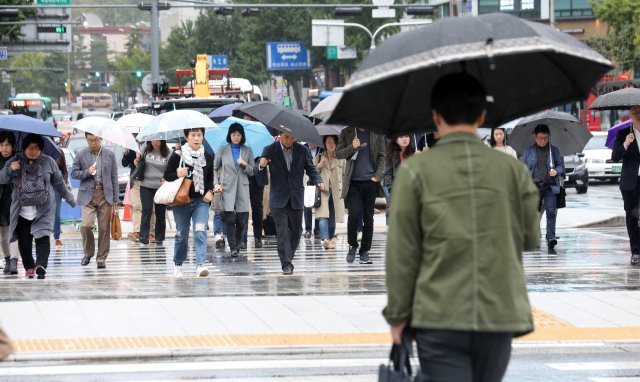 서울지역에 비가 내린 5일 오전 서울 광화문 광장에서 우산을 쓴 시민들이 출근길을 재촉하고 있다. 기상청은 이날 전국이 태풍 ‘콩레이’의 영향으로 전국이 흐리고 비가 내리겠다고 예보했다. 2018.10.5/뉴스1 © News1