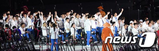 아시아 최고의 장애인 스포츠 축제 ‘’2018 인도네시아 장애인아시아경기대회‘’가 개회식을 시작으로 8일간의 열전에 돌입했다. 6일 오후(현지시간) 인도네시아 자카르타 겔로라 붕 카르노(GBK) 주경기장에서 열린 대회 개회식에 남북 단일팀이 남측 김선미(펜싱)와 북측 심승혁(수영) 한반도기 공동기수를 필두로 입장하고 있다. 장애인 국제 스포츠 대회에서 남북이 공동으로 입장한 것은 이번 대회가 처음이다. 2018.10.6/뉴스1