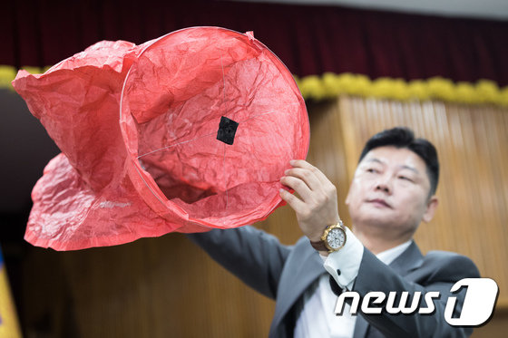 9일 경기 고양경찰서에서 열린 고양저유소 화재 사건 중간수사결과 브리핑에서 수사관계자가 화재 원인이 된 풍등과 같은 종류의 풍등을 공개하고 있다. (고양=뉴스1)