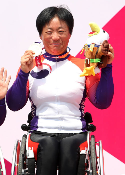 이도연이 9일 2018 장애인아시아경기 핸드사이클 여자 로드레이스(스포츠등급 H2-4)에서 금메달을 딴 뒤 시상식에서 기뻐하고 있다. 전날 여자 도로 독주에서도 우승한 그는 2개 대회 연속 2관왕이 됐다. 대한장애인체육회 제공