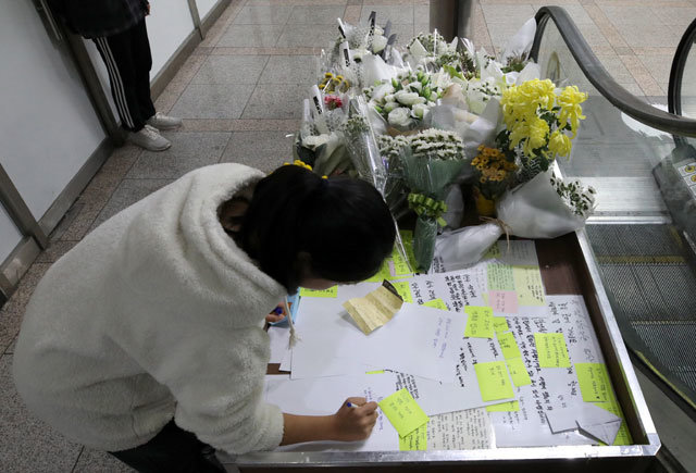 아르바이트생이 목숨을 잃은 서울 강서구의 PC방 앞에서 21일 한 시민이 추모하는 글을 쓰고 있다. 뉴스1