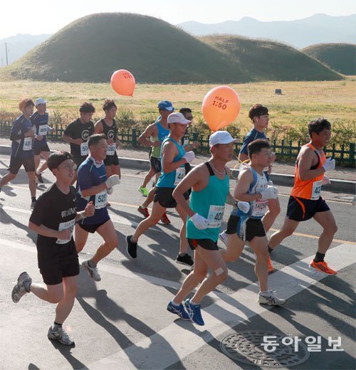 천년고도의 가을을 달리다 동아일보 2018 경주국제마라톤대회 참가자들이 21일 경북 경주시 황남동 고분공원을 따라 달리고 있다. 이날 경주시민운동장에서 출발해 경주시내를 순환해 다시 운동장으로 골인하는 코스는 첨성대 동궁 월지 등 경주의 대표 유적지를 모두 지나게 돼 마라토너들은 화창한 가을 날씨 속에 유서 깊은 천년고도의 중심부를 마음껏 질주했다. 경주=박영대 기자 sannae@donga.com