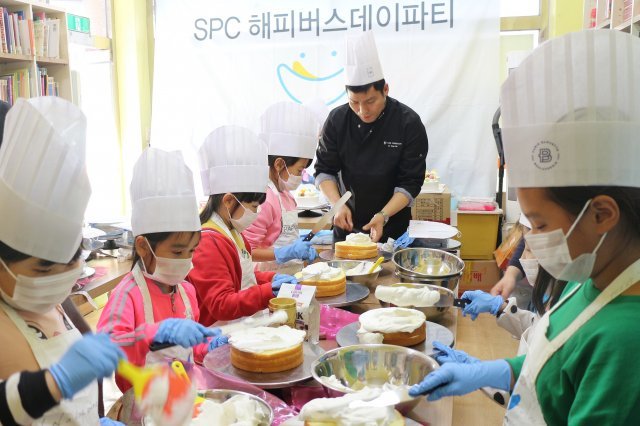 SPC해피봉사단이 23일 경기도 시흥시에 위치한 '옥터지역아동센터'에서 어린이들과 케이크 만들기 체험을 하고 있다.