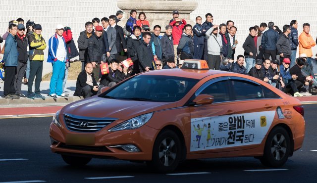 서울 광화문광장에서 열린 ‘택시 운행질서 확립 캠페인, 택시 생존권 사수 결의대회’에서 집회 참가자들이 운행중인 택시를 바라보고 있다. 택시업계는 최근 카카오모빌리티가 출시한 운전자용 카풀 애플리케이션 ‘카카오T 카풀 크루’에 대해 강력히 반발하고 있다. 2018.10.18/뉴스1