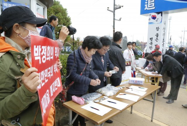 26일 경북 구미시 상모동 박정희 전 대통령 생가에서 열린 ‘박정희 대통령 제39기 추도식’장 앞에서 박정희 생가보존회에서 참석자들을 대상으로 ‘박정희대통령 역사지우기 반대 서명’을 받고 있다.2018.10.26/뉴스1 © News1