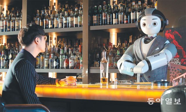24일 서울 강남구 ‘커피 바 케이’에서 인공지능(AI) 로봇 바텐더가 위스키 잔에 넣을 얼음을 깎고 있다. 이날 로봇 바텐더는 기자에게 싱글몰트 위스키 발베니에 대해 상세하게 설명해줬다. 최혁중 기자 sajinman@donga.com