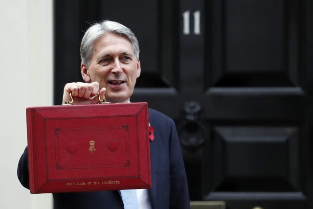 필립 해먼드 영국 재무장관이 29일 런던 관저 앞에서 예산안이 담긴 빨간 서류가방을 기자들에게 들어 보였다. 그는 이날 의회에서 “긴축정책을 끝내겠다”며 공공지출 확대를 골자로 한 예산안을 발표했다.