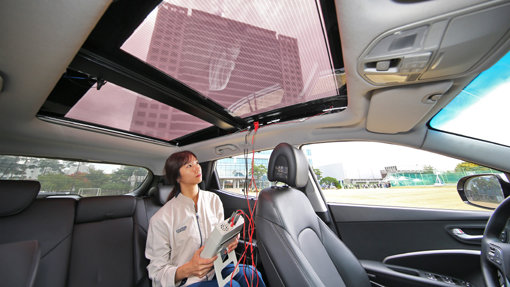 현대·기아차 연구원이 투광이 가능한 2세대 솔라루프가 설치된 자동차 안에서 효율을 측정하고 있다. 현대·기아차는 태양광을 이용해 달리는 자동차를 충전하는 솔라 시스템 관련 기술을 공개했다. 사진제공｜현대·기아차