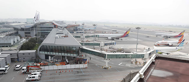 9년에 걸친 리모델링 공사를 마치고 최근 새 단장을 마무리한 김포국제공항 국내선 터미널과 활주로 모습. 항공기들이 이륙에 앞서 터미널 탑승교에서 승객을 태우고 있다.  한국공항공사 제공