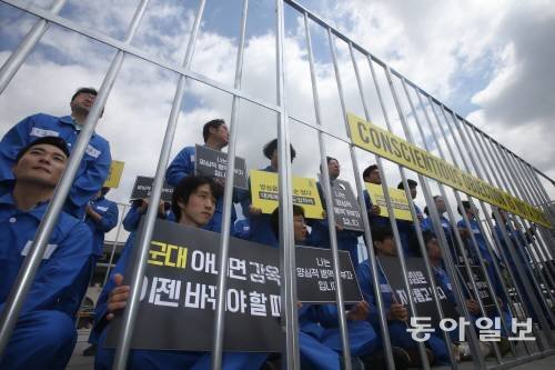 인권단체 국제앰네스티 한국지부 활동가들과 양심적 병역거부자들이 ‘세계 병역거부자의 날’인 2017년 5월 15일 오전 서울 종로구 광화문광장에서 피켓을 들고 철창에 갇힌 모습을 연출하고 있다. 사진=박영대 기자 sannae@donga.com