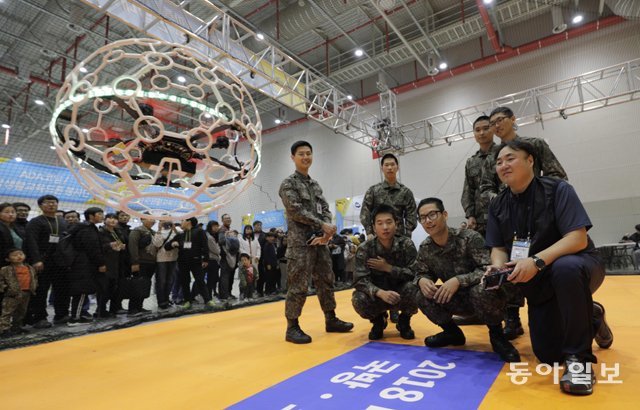 3일 경북 구미에서 열린 2018 스마트 국방·드론 산업대전을 관람하러 온 국군 장병들이 경기용 드론을 직접 날려보고 있다. 구미=박해윤 기자 land6@donga.com