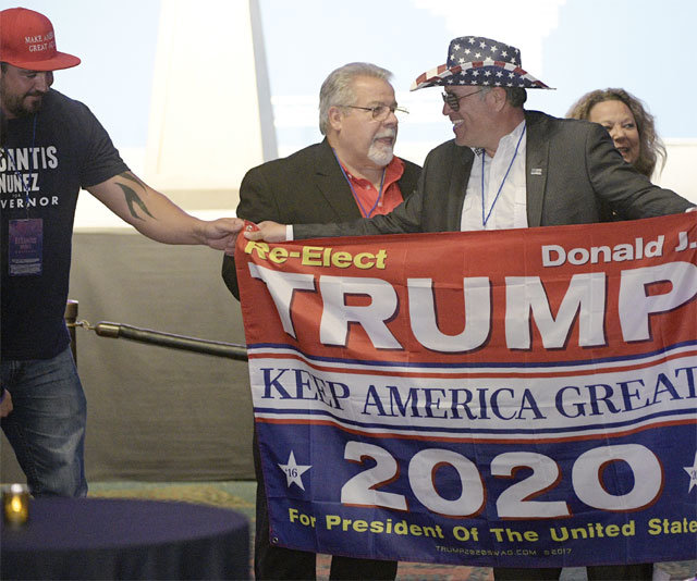 미국 중간선거가 치러진 6일(현지 시간) 플로리다주 올랜도에서 한 공화당 지지자(오른쪽)가 도널드 트럼프 대통령의 2020년 재선을 바라는 내용의 펼침막을 들고 서 있다. 올랜도=AP 뉴시스