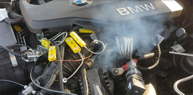 BMW 차량 화재 원인을 조사하는 민관합동조사단의 차량 화재 실험 모습. 배기가스재순환장치(EGR) 내부품 결함으로 인해 고온의 배기가스가 엔진으로 유입되고, 이로 인해 불꽃 및 천공을 유발하면서 엔진 부분에서 연기가 나고 있다. 한국교통안전공단 제공