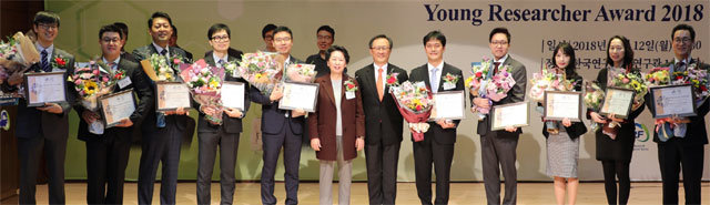 12일 한국연구재단 대전청사에서 열린 ‘올해의 신진연구자 2018’ 수상자들이 단상에서 기념 촬영을 하고 있다. 왼쪽부터 서재홍 왕동환 유창현 정재웅 최준일 교수, 노정혜 한국연구재단 이사장, 지영석 엘스비어 회장, 김성연 정효성 제유진 구민정 윤장혁 교수. 한국연구재단 제공