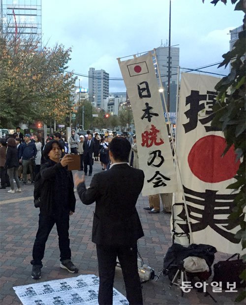 한편 공연장 밖에서는 일본 우익단체 소속의 한 남성(뒷모습)이 “BTS 공연 중지”를 외치며 기습시위를 벌였다. 휴대전화로 이 남자를 촬영하고 있는 사람은 이 시위에 항의하며 시위를
 중지할 것을 요구했다. 도쿄=김범석  특파원  bsism@donga.com
