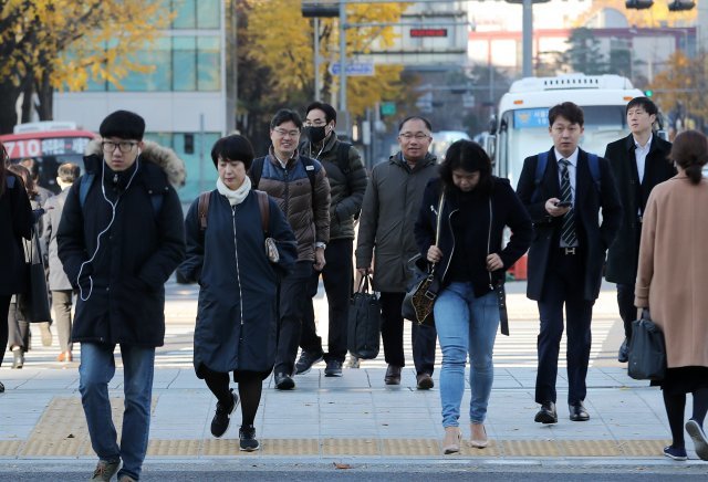 12일 오전 서울 광화문네거리에서 두터운 옷을 입은 시민들이 출근길 발걸음을 옮기고 있다. 기상청 관계자는 이날 일교차가 10도 안팎으로 크므로 건강관리에 유의할 것을 당부했다. 2018.11.12/뉴스1 © News1