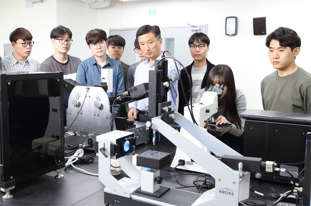 단국대 융합기술대 디스플레이공학과 한관영 교수(오른쪽에서 네 번째)가 학생들을 지도하고 있다. 한 교수팀은 지난해 6월 포스텍 이문호 교수팀과 손잡고 세계 최초로 나노기술을 활용해 미세 흠집이 나지 않는 특수 코팅 재료와 공정을 개발했다. 단국대 제공