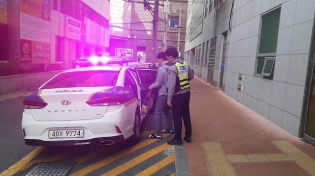 15일 오전 6시50분쯤 부산 동구에 있는 한 대형 백화점 앞에서 수험생 수송을 위해 대기하고 있던 경찰이 다리가 불편한 수험생을 태우고 고사장까지 데려다주고 있다.(부산지방경찰청 제공)