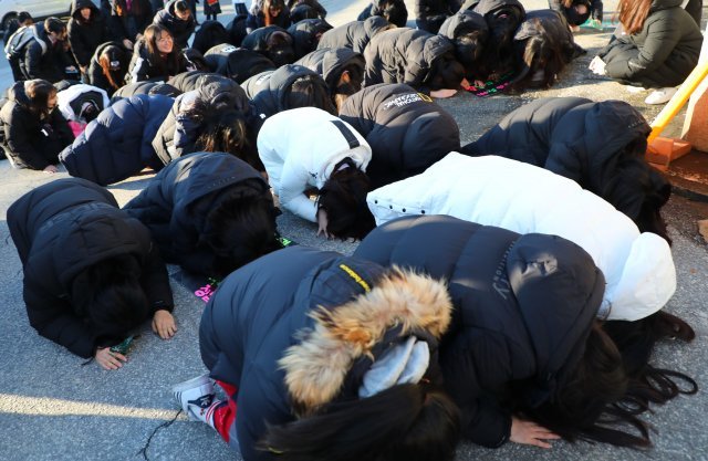 2019학년도 대학수학능력시험일인 15일 강원도 강릉시 강일여고 앞에서 후배들이 교문이 닫히자 수험생들에게 큰절하며 수능대박을 기원하고 있다. © News1