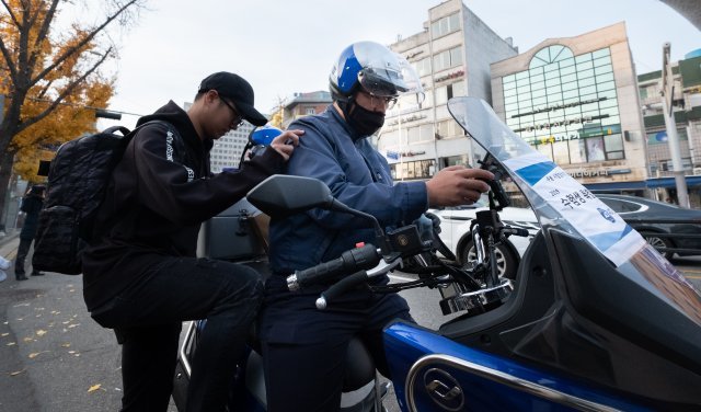 2019학년도 대학수학능력시험일인 15일 오전 서울 경복궁역 앞에서 ADT캡스 출동대원이 오토바이에 수험생을 태워 수능 시험장으로 이동하고 있다. (ADT캡스 제공) 2018.11.15/뉴스1