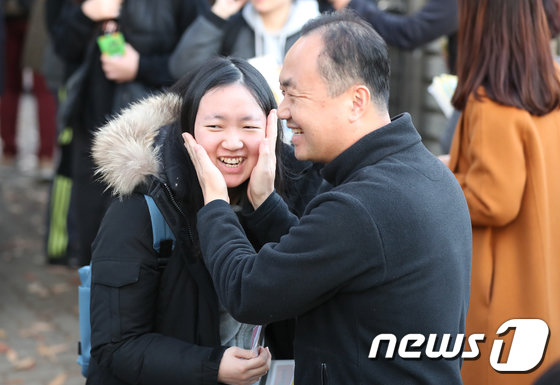 2019학년도 대학수학능력시험일인 15일 오후 대구 수성구 정화여고에서 수능 시험을 마친 수험생이 시험장 밖으로 나오자 기다리던 아버지가 뺨을 어루만지고 있다. 2018.11.15/뉴스1