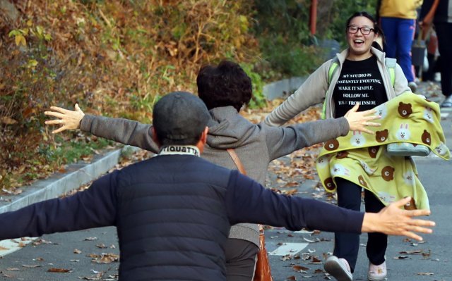 2019학년도 대학수학능력시험일이 치러진 15일 오후 광주 남구 동아여자고등학교에서 시험을 본 한 수험생이 시험장을 빠져나오며 부모에게 안기고 있다.2018.11.15/뉴스1