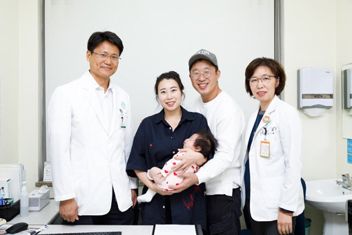 간이식 수술을 극복하고 건강한 여자 아이를 출산한 박혜령 씨가 남편과 이대목동병원 홍근 교수(맨 왼쪽), 박미혜 교수(맨 오른쪽)와 함께 기념 촬영을 하고 있다. 사진제공｜이대목동병원