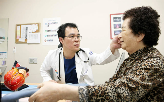 인하대병원 심장내과 백용수 교수(왼쪽)가 최근 심장재동기화치료 시술을 받은 백송자 씨와 대화를 나누며 심장 상태를 살펴보고 있다. 인하대병원 제공