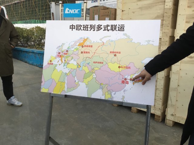 9일 중국 칭다오항 관계자가 항만 구역 현장에서 유라시아와 칭다오, 그리고 인천을 잇는 빨간 선이 그려진 지도를 가리키며 한중일 합동 취재 기자단에 설명하고 있다.