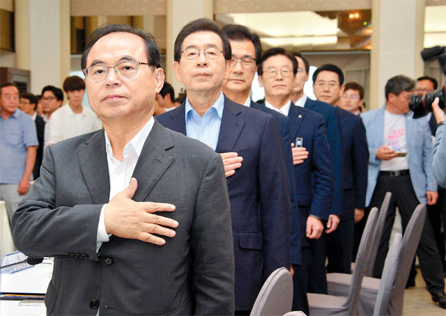 올 8월 서울 한국프레스센터에서 열린 전국 시도지사협의회 총회에 참석한 오거돈 부산시장(왼쪽에서 첫 번째)과 박원순 서울시장(왼쪽에서 두 번째)이 국기에 대한 경례를 하고 있다. 부산시 제공