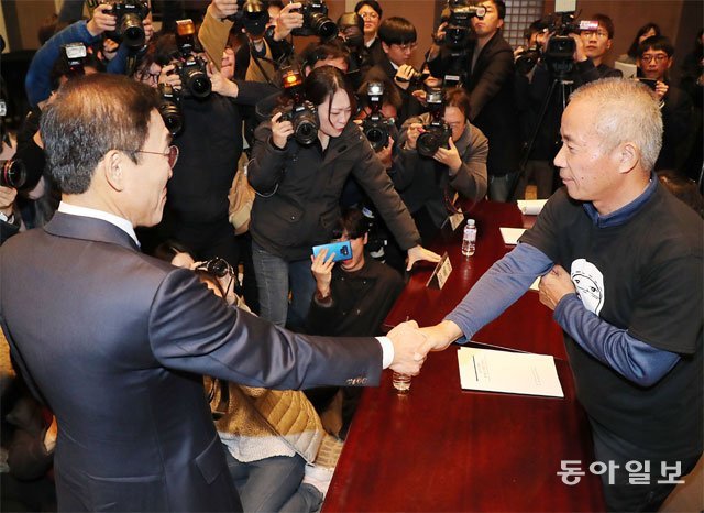 김기남 삼성전자 DS 사업부문 대표(왼쪽)와 황상기 반올림 대표가 23일 ‘삼성전자-반올림 중재판정 이행합의 협약식’에서 협약서에 서명한 후 서로 악수하고 있다. 전영한 기자 scoopjyh@donga.com