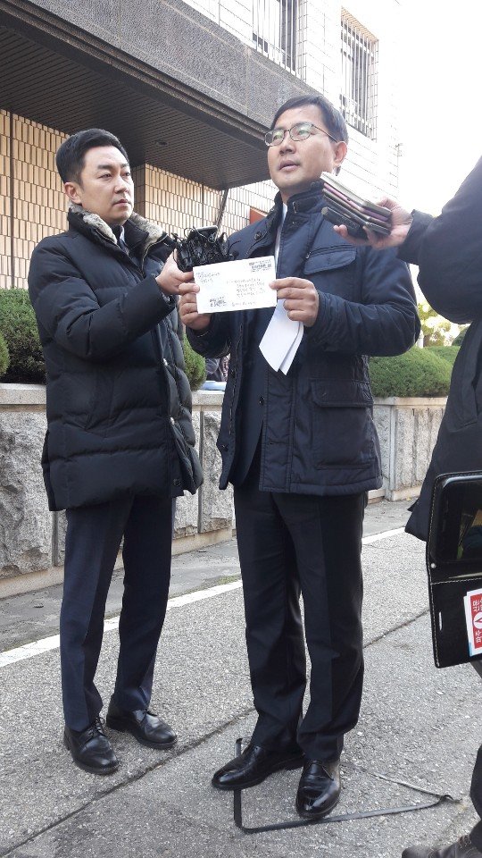 23일 수원지방검찰청에 고발 대리인으로 출석한 백종덕 변호사가 제보자의 진정서를 펼쳐 보이고 있다.© News1