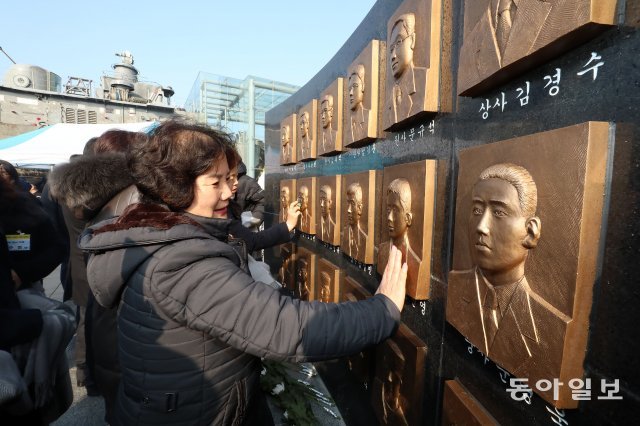 천안함 46용사 추모비 건립 기념행사가 24일 오전 경기 평택 2함대 사령부 천안함 전시시설 앞에서 열렸다. 유가족과 해군 장병 등 200 여명이 참석한 가운데 고 조진영 중사의 어머니가 아들의 부조를 만지며 울고 있다. 사진 뒷편으로 천안함이 보인다. 전영한 기자 scoopjyh@donga.com