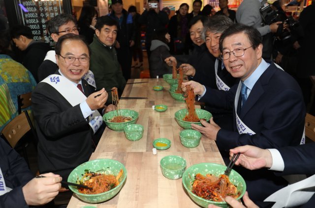 오거돈 부산시장(왼쪽)과 박원순 서울시장이 23일 오후 부산 깡통시장 내 분식점에서 비빔당면을 먹고 있다. 이날 오 시장, 박 시장은 전국 최초 상설 야시장인 부평깡통야시장을 찾아 소상공인 간편결제 서비스인 ‘제로페이’를 알렸다. 2018.11.23/뉴스1 © News1