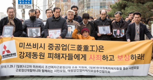 일제 강점기 근로정신대 피해자인 김성주 할머니(가운데)가 29일 대법원에서 열린 일본 미쓰비시중공업 상대 손해배상청구 소송 선고 공판에 들어서기에 앞서 기자들을 향해 손을 들어 보이고 있다. © News1