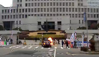 지난 27일 오전 김명수 대법원장 출근 차량이 대법원 정문 앞을 지날 때 한 남성이 화염병을 투척하고 있다. (김정수씨 제공)/뉴스1 © News1