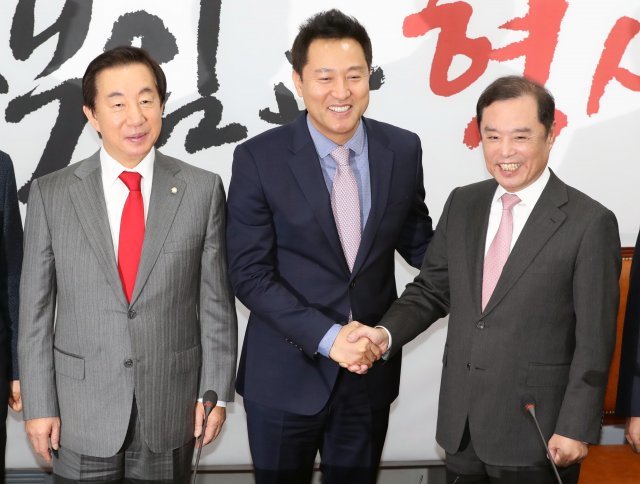 오세훈 전 서울시장이 29일 오전 서울 여의도 국회에서 열린 자유한국당 입당 환영식에서 김병준 비상대책위원장의 손을 잡은 채 활짝 웃고 있다.2018.11.29/뉴스1 © News1