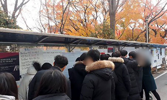 캠퍼스 탐방을 온 경인중 남학생들이 28일 서울 숙명여대에 붙은 페미니즘 관련 내용의 대자보 앞에 몰려들어 구경하고 있다. 트위터 화면 캡처