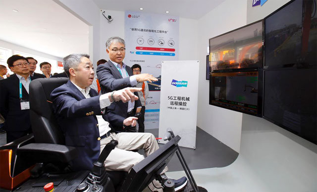 29일 박정원 두산그룹 회장이 중국 상하이에서 열리고 있는 국제 건설기계 전시회 ‘바우마 차이나’에 설치된 두산인프라코어 부스를 찾아 5세대(5G) 원격제어 기술로 인천공장에 있는 굴착기를 작동해 보고 있다. 두산그룹 제공