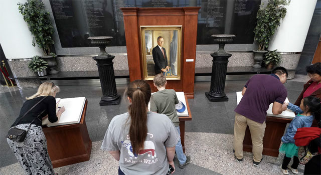 추모하는 미국인들 11월 30일 별세한 조지 부시 전 미국 대통령의 추모대가 차려진 텍사스주 칼리지스테이션에서 추모객들이 고인의 영정 앞에 놓인 방명록에 애도를 표하는 글을 적고 있다. 칼리지스테이션=AP 뉴시스