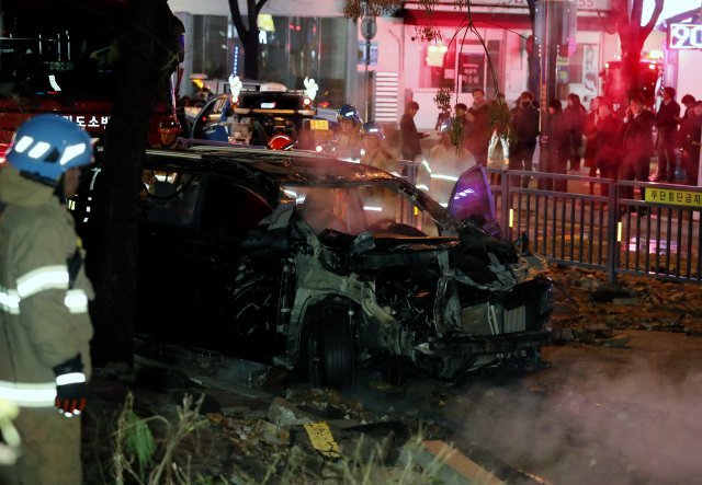 한국지역난방공사 고양지사의 배관이 파열돼 뜨거운 물이 도로 위로 분출된 4일 밤 경기도 고양시 일산동구 백석역 인근 사고 현장에 소방대원들이 처참한 모습의 차량을 살펴보고 있다. 2018.12.5/뉴스1 © News1