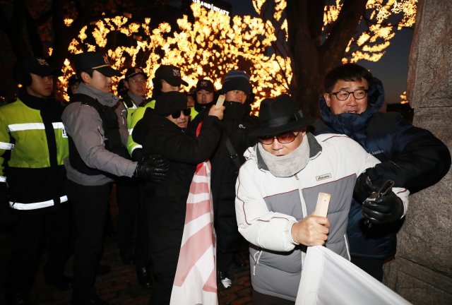 시민단체 회원이 7일 오후 아키히토 일왕의 생일 기념행사가 열린 그랜드하얏트호텔 행사장으로 향하자 경찰에게 저지당하고 있다. 일본은 아키히토 일왕의 생일(12월23일)을 국경일로 지정해 축하하고 있다. 2017.12.7/뉴스1 © News1