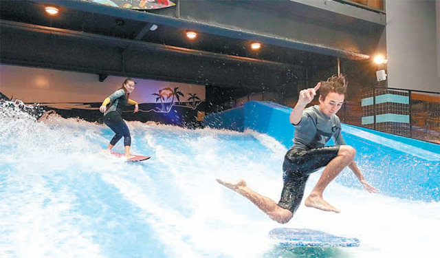 유통업계 최초로 들어선 실내 서핑숍에서 선수들이 고객들에게 서핑하는 모습을 보여주고 있다.