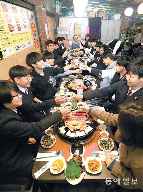 성적이 우수한 학생과 향상된 학생들에게 동문들이 모금해 삼겹살 파티를 한다. 4일 오후 서울 종로구 한 식당에서 선생님과 학생들, 동문 선배들이 함께 식사를 하고 있다. 안철민 기자 acm08@donga.com